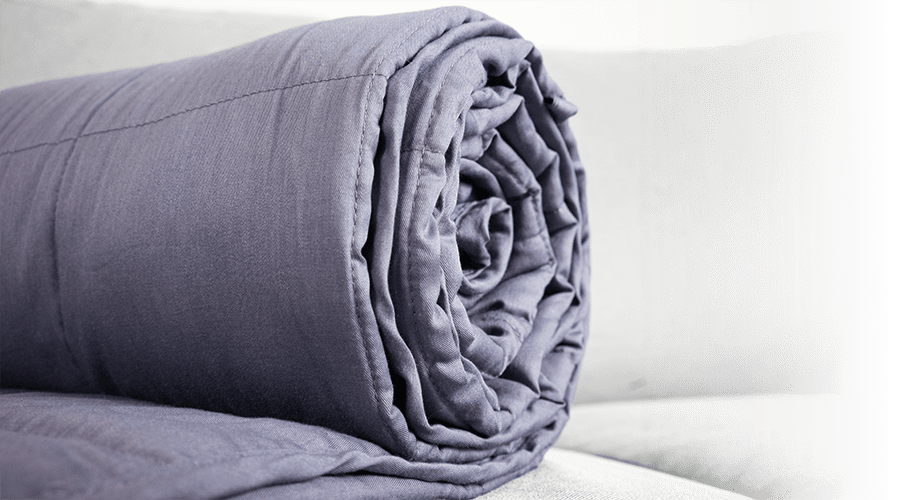 Cotton weighted blanket rolled up on a sofa
