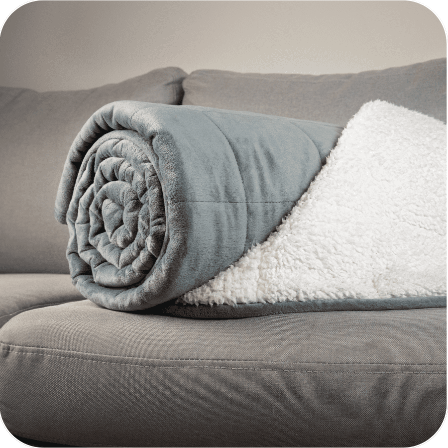Close-up of rolled blue weighted blanket on sofa